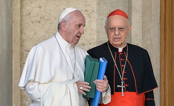 Pope Francis (L) speaks with italian cardinal Lorenzo Baldisseri as he leaves the morning session of the last day of the Synod on the Family at the Vatican on October 24, 2015. Pontiff on October 4 defended marriage and heterosexual couples as he opened a synod on the family overshadowed by a challenge to Vatican. Pope Francis accelerated his streamlining of the Vatican bureaucracy by announcing plans to create a new ministry which will increase the role of lay believers in the Church. The Pontiff made the announcement to an afternoon session of the synod, which is due to conclude at the weekend after three weeks of often heated discussions on issues such as divorce, homosexuality and cohabitation. AFP PHOTO / ANDREAS SOLARO